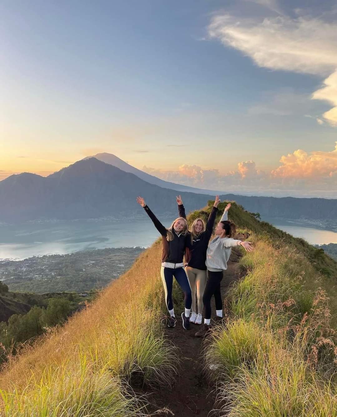 Pendaki menikmati pemandangan indah dari puncak bukit di Indonesia saat hiking pagi